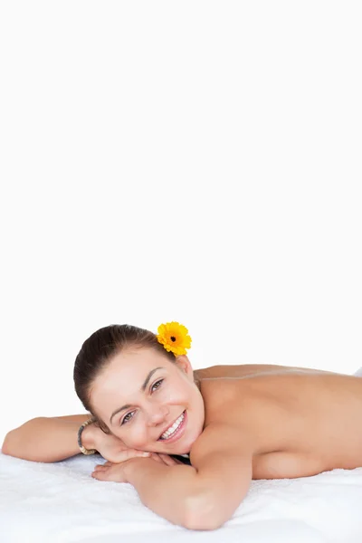 Портрет усміхненої брюнетки з квіткою на її вухо — стокове фото