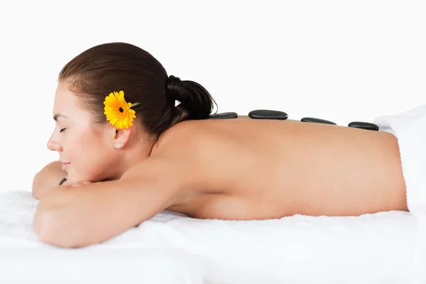 Vacker kvinna med en massage med varma stenar — Stockfoto