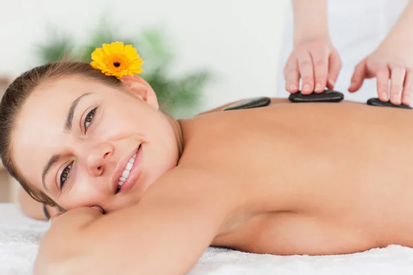 Charming woman having a hot stone massage — Stock Photo, Image
