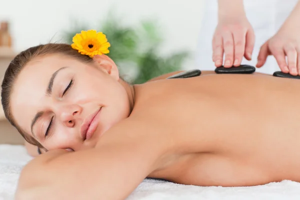 Mujer encantada teniendo un masaje de piedra caliente —  Fotos de Stock
