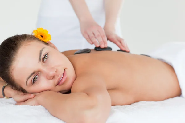 Close up of a delighted woman having a hot stone massage — Stock Photo, Image