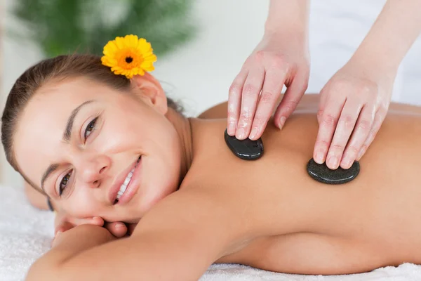 Bliska uśmiechający się kobieta korzystających masaż gorącymi kamieniami — Zdjęcie stockowe