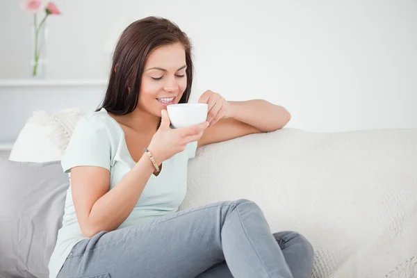 Cute dark-haired woman drinking tea — Stock Photo, Image