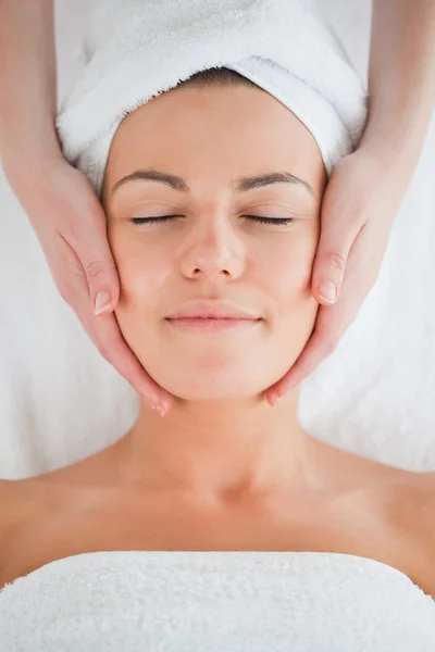 Portret van een mooie brunette met een gezicht massage — Stockfoto