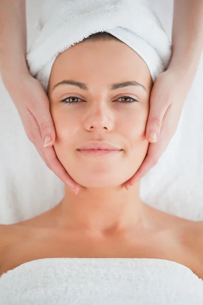 Ritratto di una affascinante bruna che fa un massaggio facciale — Foto Stock