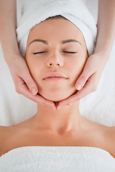 Retrato de uma morena encantada fazendo uma massagem facial — Fotografia de Stock