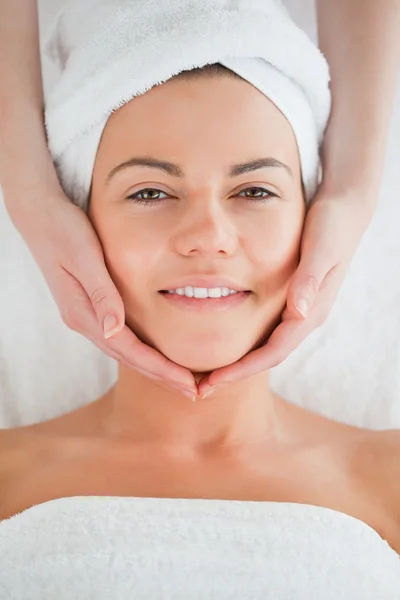Ritratto di una bruna sorridente che fa un massaggio facciale — Foto Stock