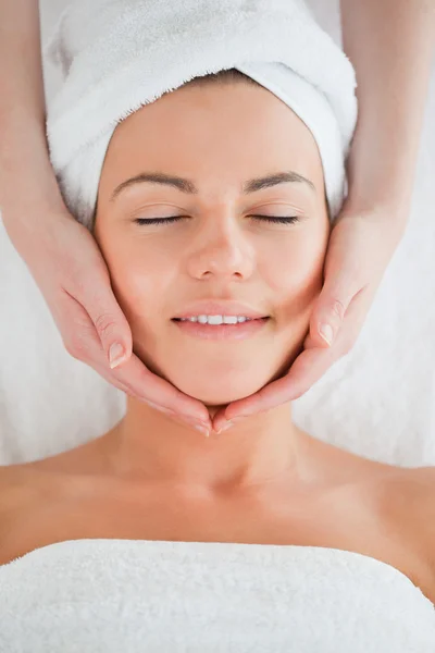 Retrato de uma mulher sorridente fazendo uma massagem facial — Fotografia de Stock