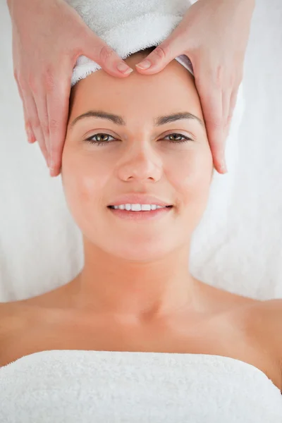 Retrato de una mujer sonriente disfrutando de un masaje facial — Foto de Stock