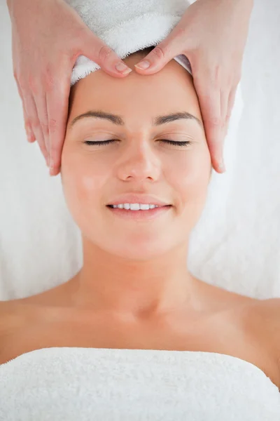 Retrato de uma mulher feliz desfrutando de uma massagem facial — Fotografia de Stock