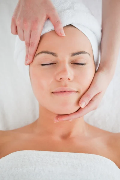 Retrato de uma mulher desfrutando de uma massagem facial — Fotografia de Stock