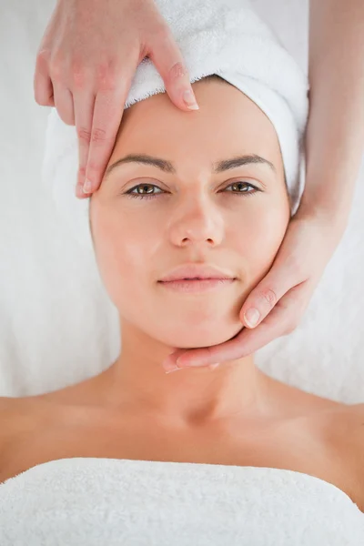 Retrato de uma mulher bonita desfrutando de uma massagem facial — Fotografia de Stock