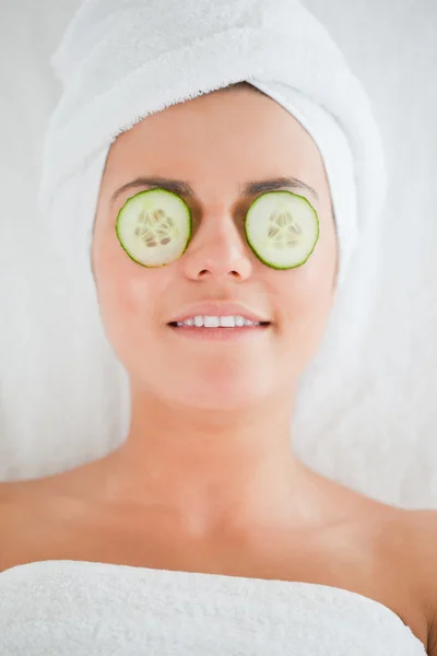 Lachende vrouw met plakjes komkommer op het gezicht — Stockfoto