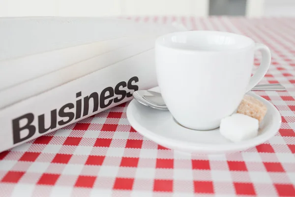Uma xícara de chá e um jornal em uma toalha de mesa — Fotografia de Stock