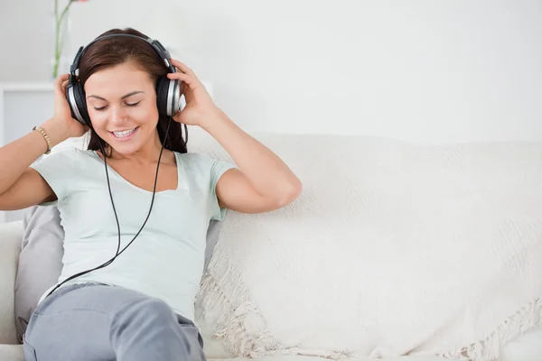 Улыбающаяся молодая женщина слушает музыку — стоковое фото