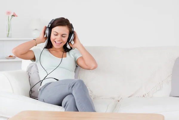 Lachende brunette luisteren naar muziek — Stockfoto