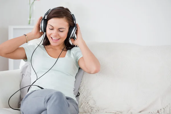 Charmiga brunett lyssna på musik — Stockfoto
