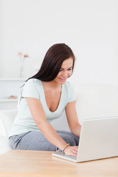 Mujer joven linda escribiendo en su computadora portátil — Foto de Stock