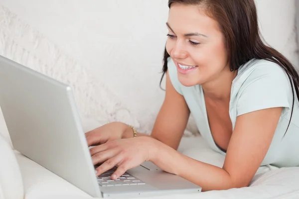 Close up de uma jovem mulher em um sofá usando um laptop — Fotografia de Stock