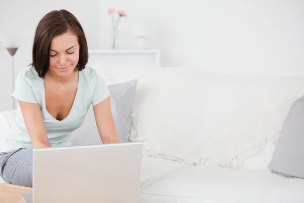 Młoda brunetka wpisując na jej laptopie — Zdjęcie stockowe