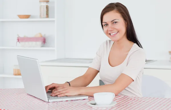 Brünette mit ihrem laptop und mit einem tee — Stockfoto