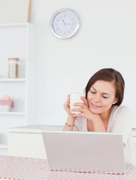 Προσωπογραφία γυναίκας χρησιμοποιώντας το laptop της και έχοντας ένα τσάι一个女人用她的笔记本电脑和喝茶的肖像 — 图库照片