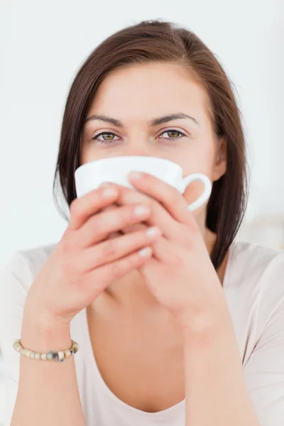 Улыбающаяся темноволосая женщина пьет чай — стоковое фото