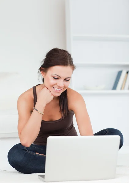 Beautiful young brunette using her laptop — Stock Photo, Image