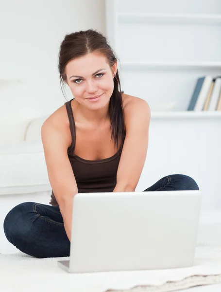 Hermosa mujer de cabello oscuro usando su computadora portátil — Foto de Stock