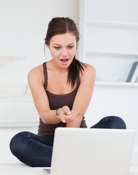 Zaskoczony ciemnowłosa kobieta za pomocą swojego laptopa — Zdjęcie stockowe
