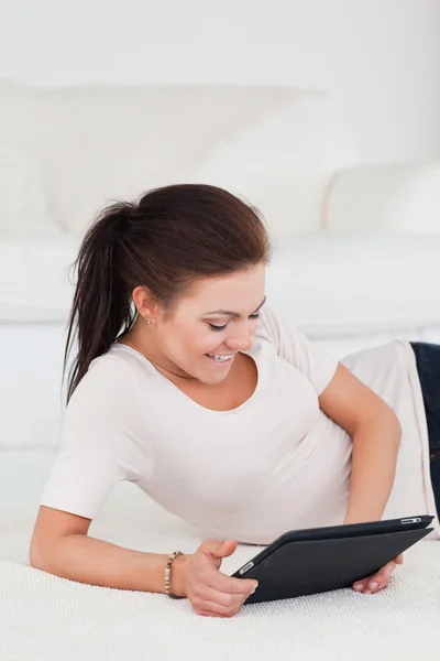 Smiling dark-haired woman using a tablet — Stock Photo, Image