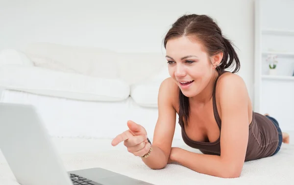 Mujer linda apuntando a la pantalla de su computadora portátil — Foto de Stock