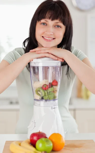 Beautiful brunette woman posing with a mixer while standing — Stock Photo, Image