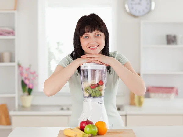 Mulher morena bonita posando com um mixer enquanto está de pé — Fotografia de Stock