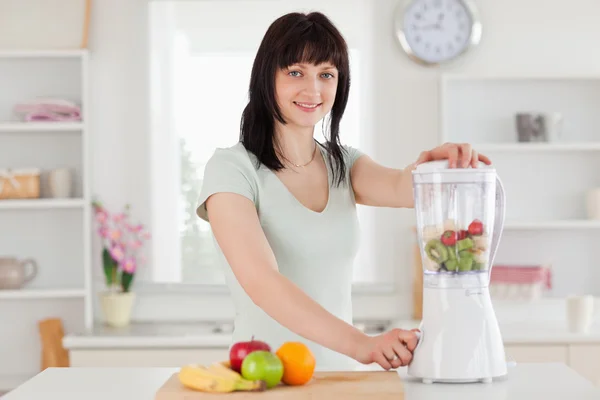 Charming brunette woman using a mixer while standing — Stock Photo, Image