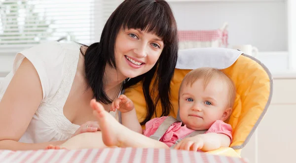 Beautiful brunette woman posing with her baby while sitting — Stock Photo, Image