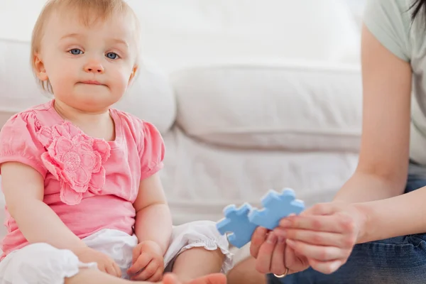 Nő mutató egy puzzle-darabot, hogy a baba ülve, a ponty — Stock Fotó