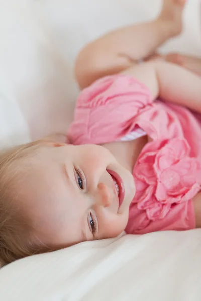 Aranyos szőke baba feküdt egy ágyon — Stock Fotó
