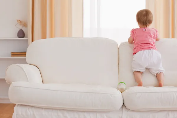 Blond baby permanent op een sofa — Stockfoto