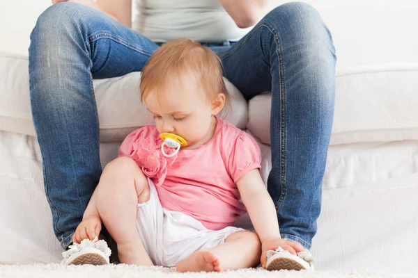 Bebê brincando com os pés de sua mãe enquanto sentado em um tapete — Fotografia de Stock