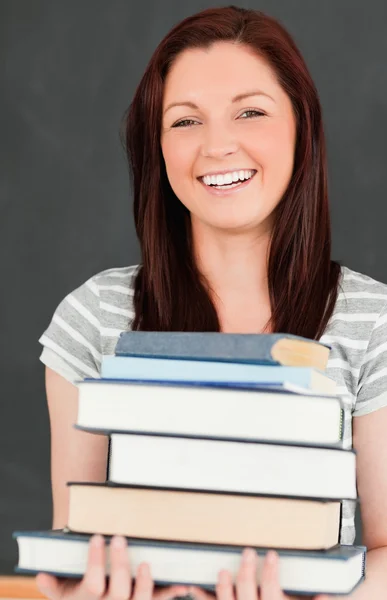 Смеющаяся молодая женщина приносит книги Стоковое Изображение
