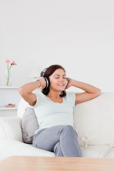Delighted dark-haired woman listening to music — Stock Photo, Image