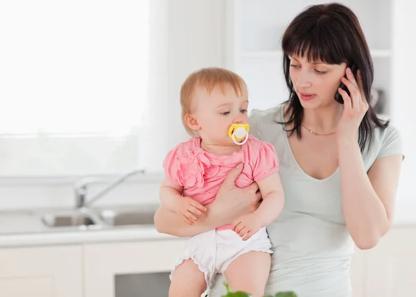 Belle Femme Au Telephone Tout En Tenant Son Bebe Dans Ses Bras Mere Style De Vie Stock Photo