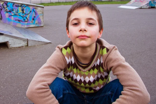 Söt pojke sitter på lekplats — Stockfoto