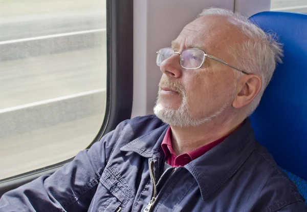 Avslappnad gammal man sitter nära fönstret i vagnen — Stockfoto