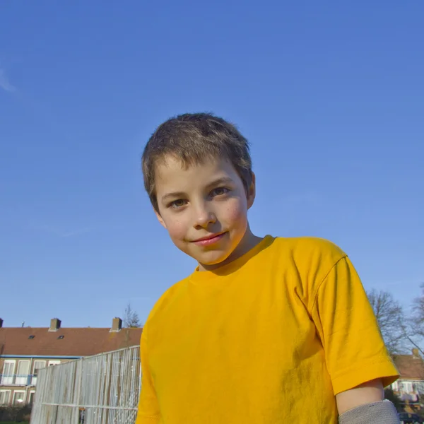 Šťastné dospívající chlapec na pozadí modré oblohy — Stock fotografie