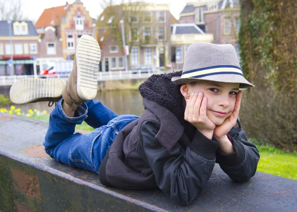 Śmieszne nastoletniego chłopca leżącego na parapet w parku — Zdjęcie stockowe