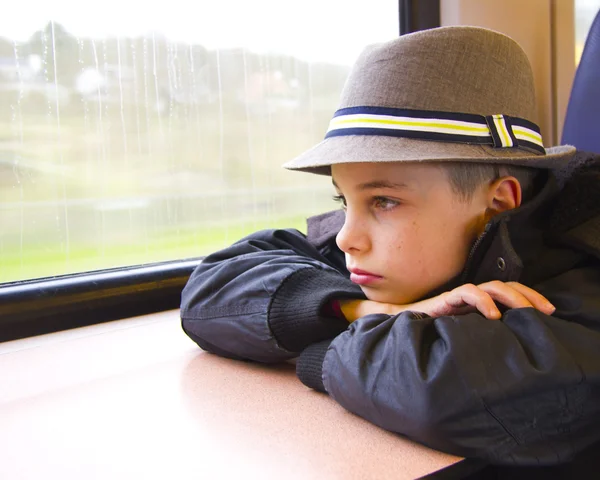 沉思十几岁的男孩，在运输中的窗口 — 图库照片