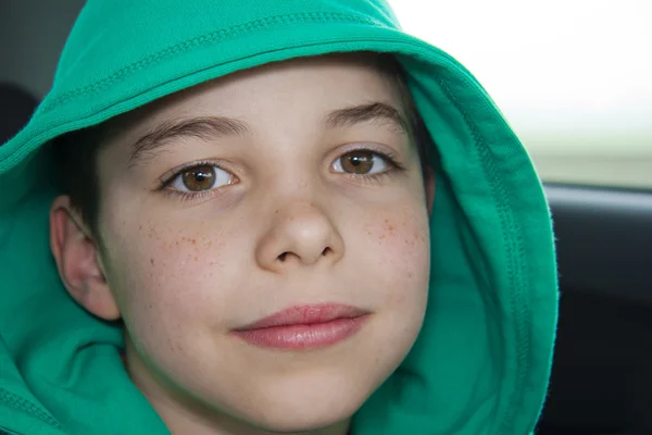 Крупный план симпатичного мальчика в зеленом капюшоне — стоковое фото