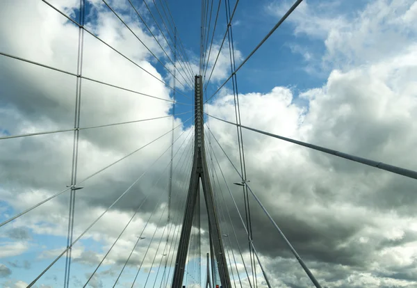 Marco da ponte de aço prata moderna contra um céu azul nublado — Fotografia de Stock